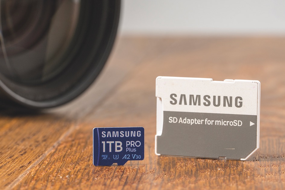 Two small SD cards from Samsung sitting on a wooden table