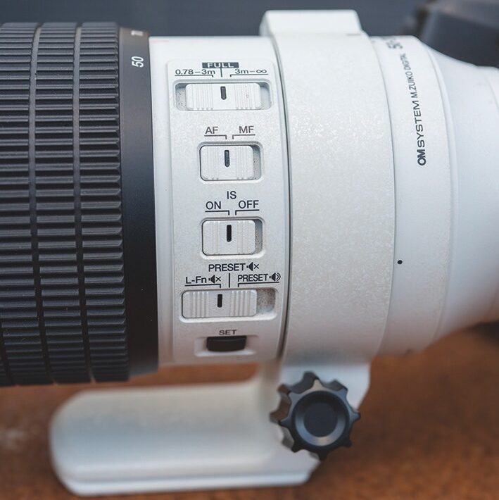 Close up of the buttons on the side of an Om System lens