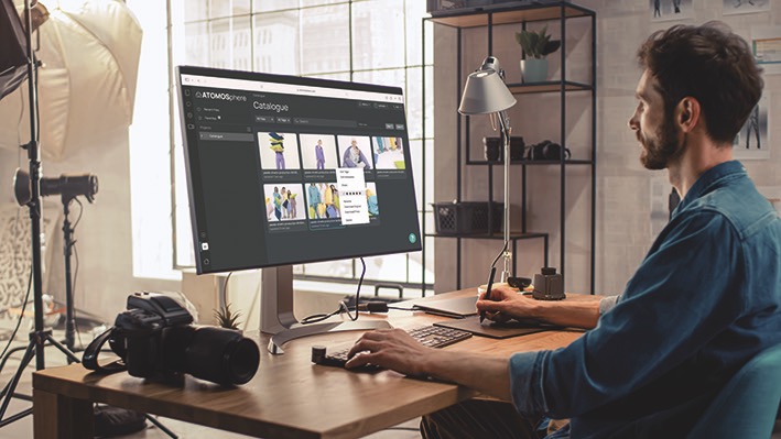 A man working on a large computer, using a programme by Atomos