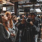 A group crowds around a person operating a camera in CVP