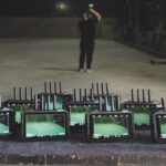 A collection of Accsoon monitors showing a green room, sitting on a wooden table