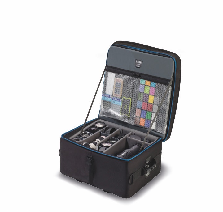A soft black case from Tenba with netting and compartments filled with videography equipment, against a white background