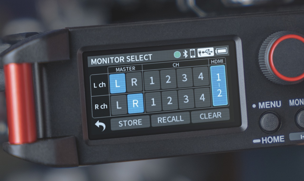 Close up of the screen of a Tascam field recorder showing rows of numbers with a dial next to it