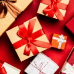 Top view of gold, silver and red Christmas presents on a red table
