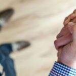 Top view of hands shaking. One person is wearing a suit