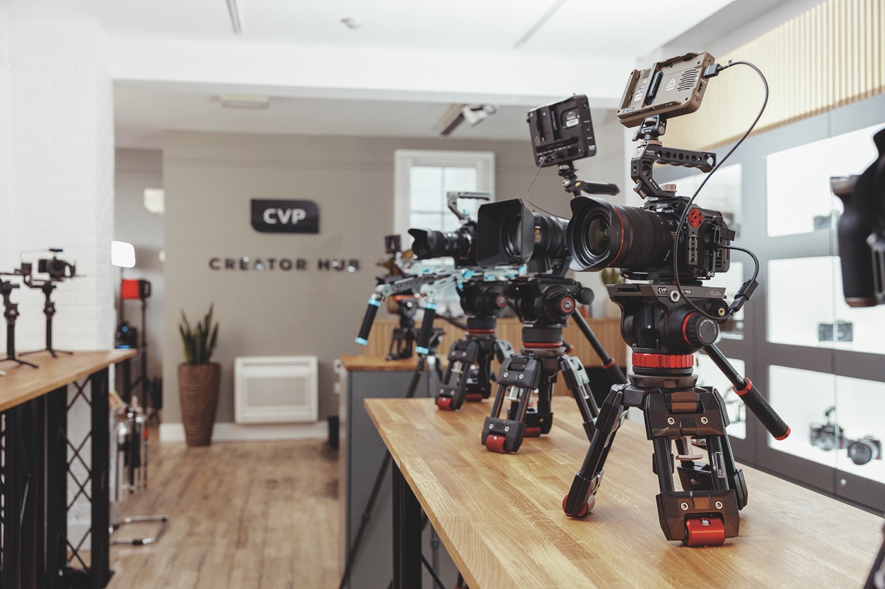 The interior of a camera store with cameras on mounts lining a table