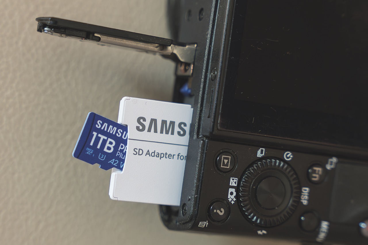 A small white adapter with a little blue SD card from Samsung inserted