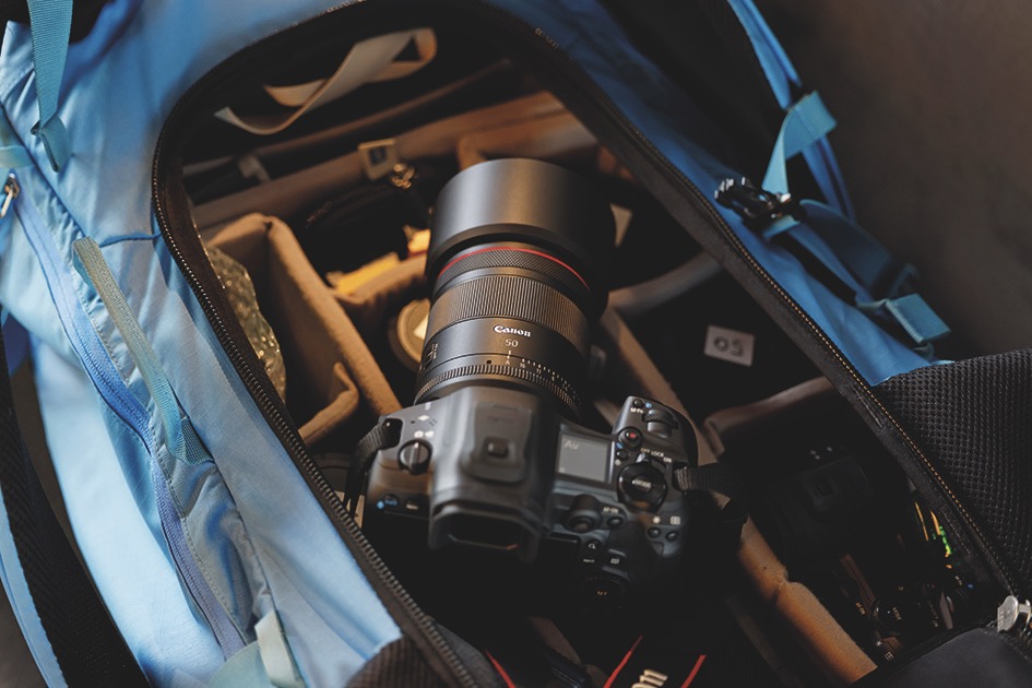 A camera placed on the top of compartments in an open blue back