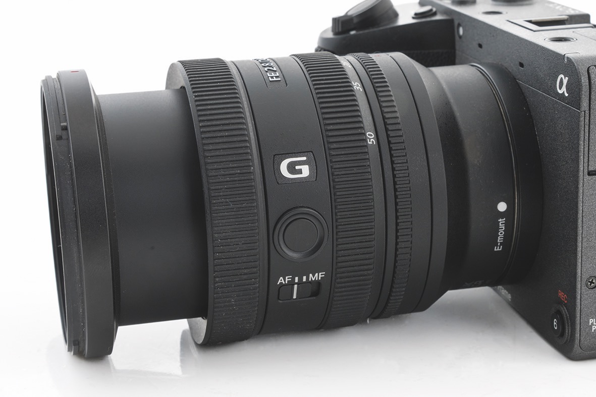 A lens from Sony attached to a camera and against a white background