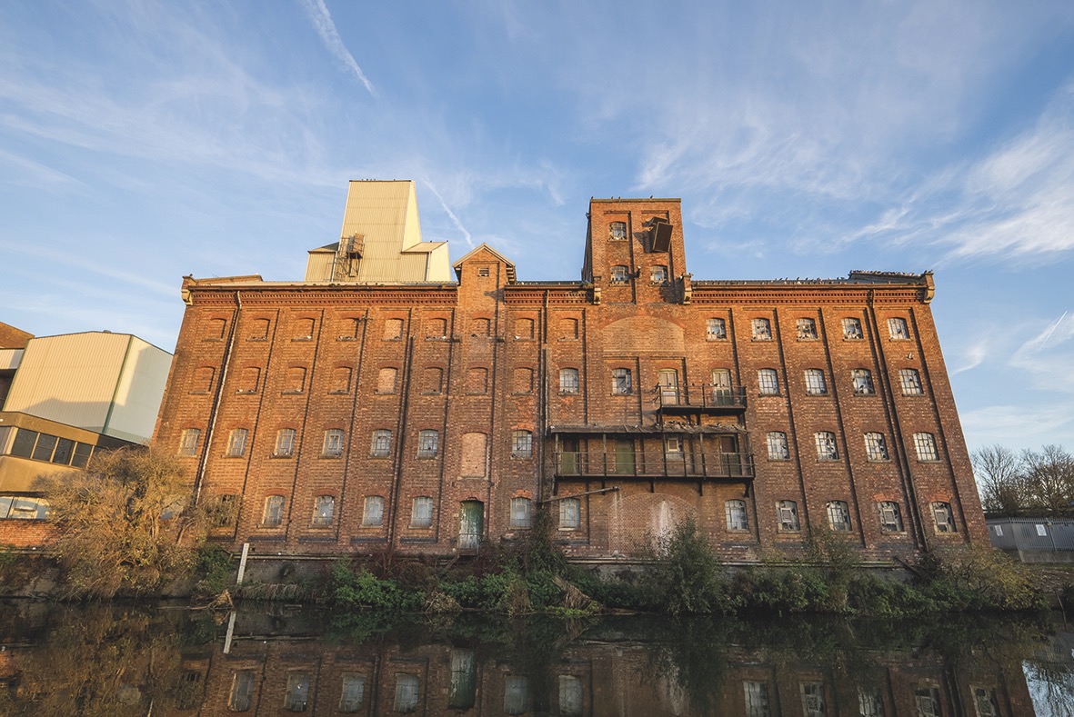 Titled angle of an orange building next to a river