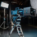 A direct-to-camera interview system from PrimeLight Design, standing in front of professional equipment in a dark studio