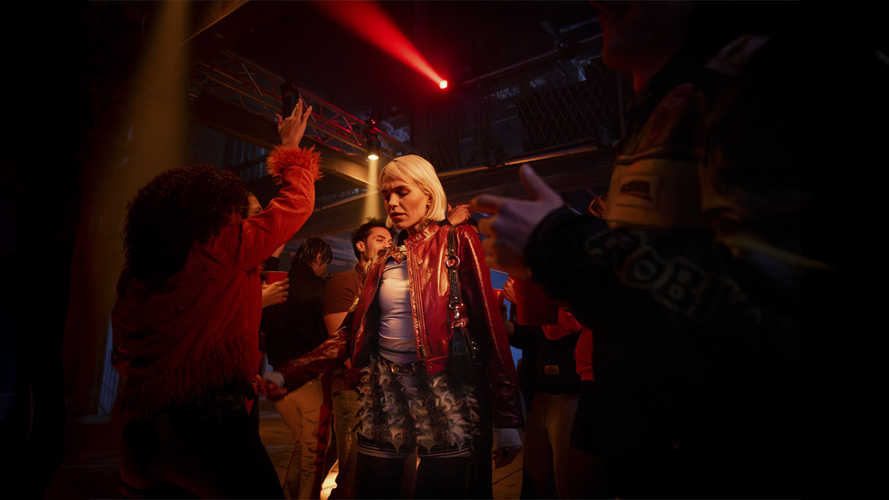 People at a club with a woman in the centre, illuminated in red