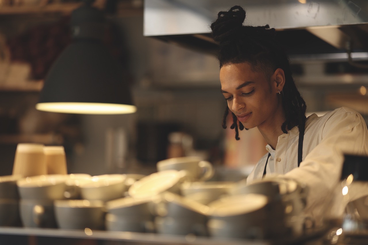 A person standing behind blurred empty cups