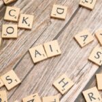 Scrabble letters on a wooden table with the letters "A" and "I" together